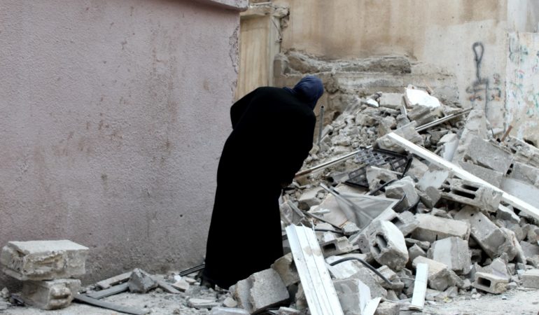 Moteris apžiūri Izraelio kariuomenės sugriautą šeimos namą Kalandijos tremtinių gyvenvietėje.
