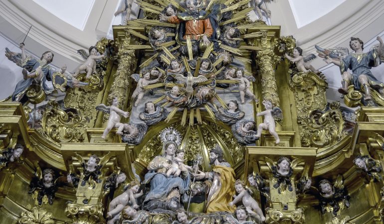 Juozapas greta Mergelės Marijos Švč. Trejybei skirtame altoriuje: basųjų karmeličių tarpe įsitvirtinusi šio šventojo gerbimo tradicija paskatino jį iškelti į tokias aukštumas, kuriose paprastai vaizduojama tik Mergelė Marija. 1732 m., Germán López, Malagón (Ispanija). Nuotr. autorės.
