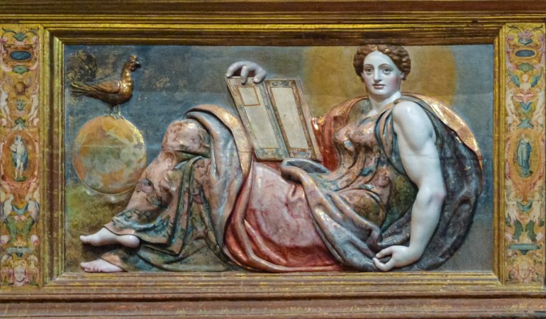 Teologinės dorybės pagrindinio altoriaus predeloje (Astorgos katedra, 1584 m., Gaspar Becerra): dosnioji meilė (caritas) – žindanti ir duoną dalijanti moteris, tikėjimas su Eucharistijos taure rankoje, viltis su užrakinta knyga ir į rojaus sodą nukreiptu žvilgsniu. Simetrijai išlaikyti jų draugija papildyta svarbiausia žmogiškąja protingumo dorybe: ji vienintelė žvelgia tiesiai į atėjusį, šalia jos ant sukurtosios visatos rutulio – budrumo simbolis gaidys, rankoje – atversta išminties knyga. Nuotrauka J.Micevičiūtės.